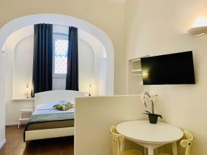 um quarto com uma cama, uma mesa e uma janela em Eccelso Suites em Roma