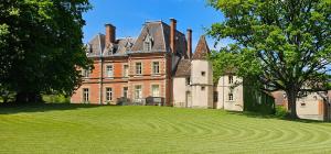 een groot huis met een groot grasveld bij Château de Montpatey in Couches
