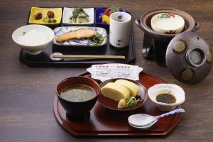 a table with a plate of food and bowls of soup at Towa Ryokan in Kyoto