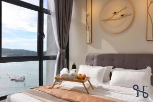 a bedroom with a bed with a view of the ocean at Homesuite' Home at The Shore in Kota Kinabalu