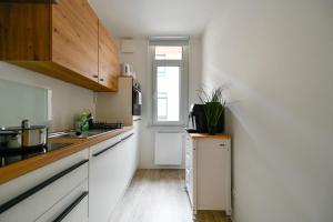 a small kitchen with white cabinets and a window at Ferienwohnungen am Theater - modern, zentral und ruhig mit Küche, Waschtrockner, Netflix, Wlan und Parkplatz- 2 Zimmer, 52 qm in Cottbus