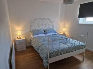 1 dormitorio con cama blanca y almohadas azules en Enfield Street house behind Portstewart promenade with partial sea view from front 3 bed sleeps 7, en Portstewart