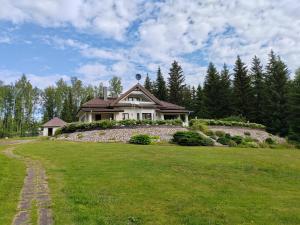 uma casa sentada em cima de um campo de relva em Villa Grinberg em Mäntyharju