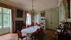 une salle à manger avec une table et des chaises blanches dans l'établissement Château de Montpatey, à Couches