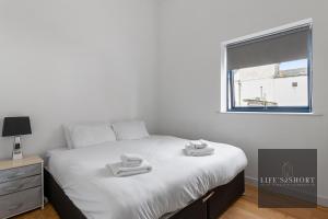 1 dormitorio con 1 cama con 2 toallas en Smythen St, 2 bed apartment with balcony, en Exeter