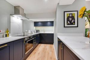 a kitchen with blue cabinets and white counter tops at Host & Stay - Catharine Quarters in Liverpool