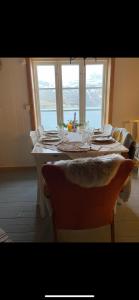 拉姆貝格的住宿－Rorbu Vestersia i Skjelfjord，餐桌、椅子和大窗户