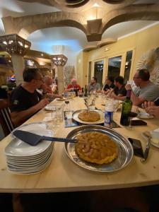 grupa ludzi siedzących przy stole z jedzeniem w obiekcie HOME LE SOFT Vic sur Cère w mieście Vic-sur-Cère