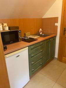 a kitchen with a counter with a microwave and a sink at Penzión Malužiná in Malužiná