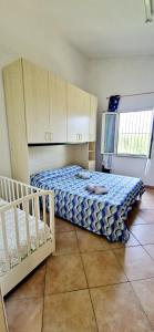 ein Schlafzimmer mit einem Bett und einer Mikrowelle in der Unterkunft Casa vacanza Su Mare Sorso a pochi m dal mare in Sorso