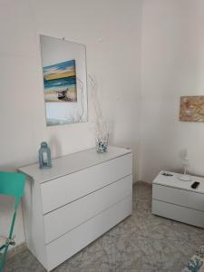 La casa di Nonna Rosa في بروسيدا: خزانة بيضاء في غرفة مع صورة على الحائط