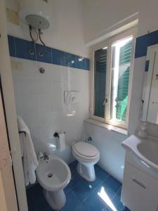 a bathroom with a white toilet and a sink at La casa di Nonna Rosa in Procida