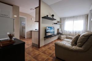 dunas da barra في Ponteceso: غرفة معيشة مع أريكة وتلفزيون بشاشة مسطحة