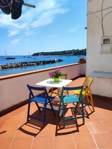 una mesa y sillas en un balcón con vistas al océano en La casa di Nonna Rosa en Procida
