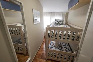 1 dormitorio con 2 literas y espejo en dunas da barra, en Ponteceso