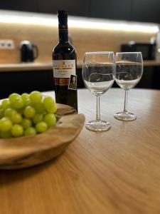 two wine glasses and a bottle of wine on a table at Apartmány Kyjov in Kyjov