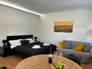 a bedroom with a bed and a table and a couch at Apartmány Kyjov in Kyjov