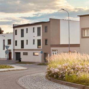 an empty street with white buildings and flowers at Apartmány Kyjov in Kyjov