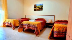 a room with two beds and a table in it at B&B La Villetta Gela in Gela