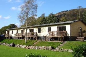 a large white building with wooden decks and a house at The Chalets in Eskdale