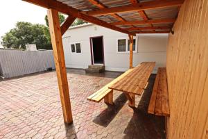 a wooden bench sitting on the patio of a house at Valea Fazanilor in Durleşti