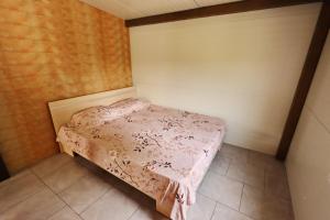 een kleine slaapkamer met een bed met een roze deken bij Valea Fazanilor in Durleşti