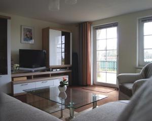 a living room with a tv and a glass coffee table at Ferienhaus Helene in Michaelsdorf