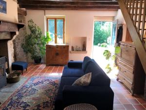 a living room with a blue couch and a fireplace at Le Moulin de la Farge B&B in Saint-Moreil