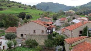 a village with houses and mountains in the background at Apartamento Bielva in Bielva