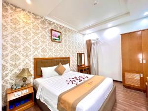 a bedroom with a bed with red flowers on it at New Space Hotel Airport in Ho Chi Minh City