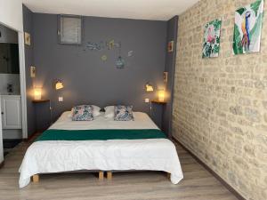1 dormitorio con 1 cama con 2 almohadas en Gîte UTAH - 4 personnes - Plages du débarquement, en Formigny