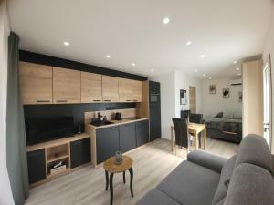 a living room with a couch and a kitchen at Villa Les palmiers in Besse-sur-Issole