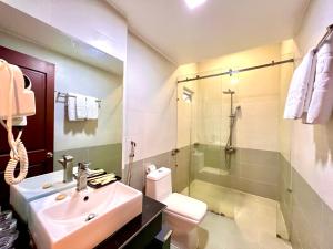 a bathroom with a sink and a toilet and a shower at New Space Hotel Airport in Ho Chi Minh City