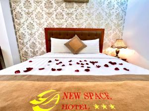a bed with roses on it with a new star hotel sign on it at New Space Hotel Airport in Ho Chi Minh City
