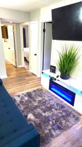 ein Wohnzimmer mit einem blauen Sofa und einem Flachbild-TV in der Unterkunft Cozy Apartment Stay (DS) in Norfolk