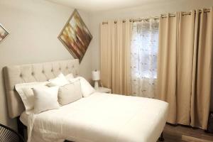 ein weißes Bett mit weißen Kissen und einem Fenster in der Unterkunft Cozy Apartment Stay (DS) in Norfolk