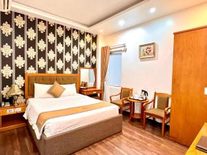 a hotel room with a bed and two chairs at New Space Hotel Airport in Ho Chi Minh City