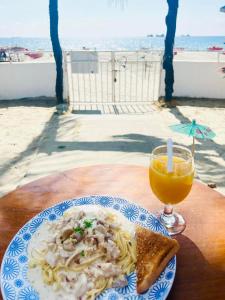 talerz makaronu i szklankę soku pomarańczowego w obiekcie North Shores Inn w mieście Currimao