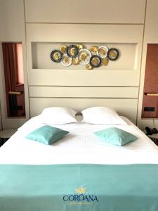 a bed with two pillows and plates on a wall at Hotel Coroana in Tîrgu Frumos