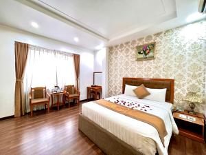 a bedroom with a bed and a table and chairs at New Space Hotel Airport in Ho Chi Minh City
