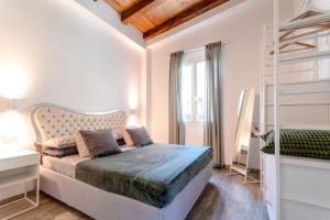 a white bedroom with a bed and a window at La Casetta in Riccò del Golfo di Spezia