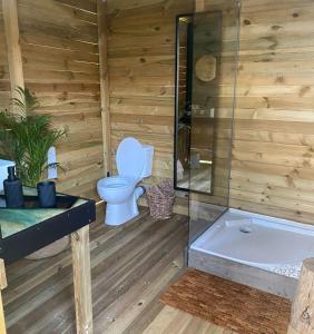 La salle de bains est pourvue de toilettes et d'une baignoire. dans l'établissement Domaine Authentique de Rose, à Porto-Vecchio