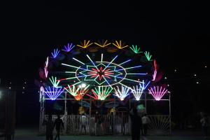 a large ferris wheel with colorful lights at night at Friends Hostel by Backpackers Heaven- New Delhi Railway Station - Paharganj in New Delhi