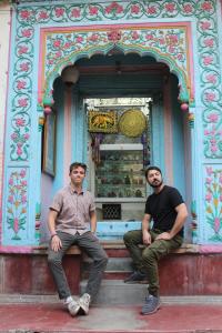 two men sitting on steps in front of a building at Friends Hostel by Backpackers Heaven- New Delhi Railway Station - Paharganj in New Delhi