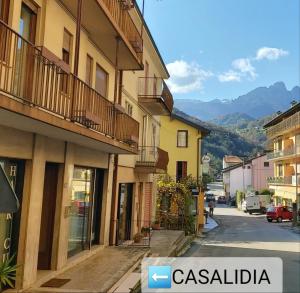 una calle en una ciudad con montañas en el fondo en CASALIDIA monolocale en Valli del Pasubio