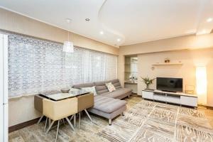 a living room with a couch and a tv at Арбат in Almaty