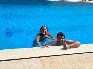 a man and a woman in a swimming pool at Royal NJ Hotel in Borg El Arab