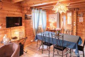 una sala da pranzo con tavolo e sedie blu di Chalet La Calougeotte avec jardin, sauna et spa intérieur privatif a Le Ménil
