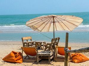 stół i krzesła na plaży z parasolem w obiekcie Loongmun Beach w mieście Cha Am