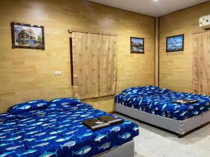two beds in a room with blue sheets at Loongmun Beach in Cha Am